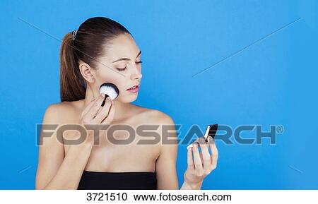 Portrait of a woman using make-up brush on face View Large Photo Image Stock Image - Portrait of a woman using make-up brush on face. Fotosearch