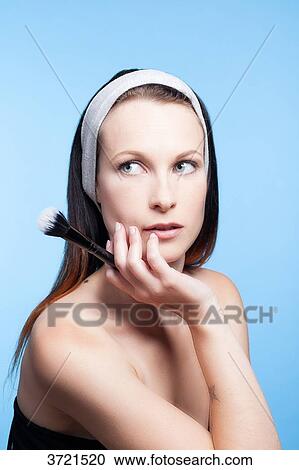 Portrait of a woman using make-up brush on face View Large Photo Image Stock Image - Portrait of a woman using make-up brush on face. Fotosearch