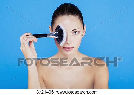Portrait of a woman using make-up brush on face View Large Photo Image Stock Photograph - Portrait of a woman using make-up brush on face. Fotosearch