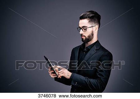 Stock Photo - Portrait of a young businessman holding a touch pad in his hands. Fotosearch
