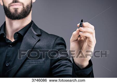 Stock Photograph - Portrait of a young businessman holding a pen in his hand. Fotosearch