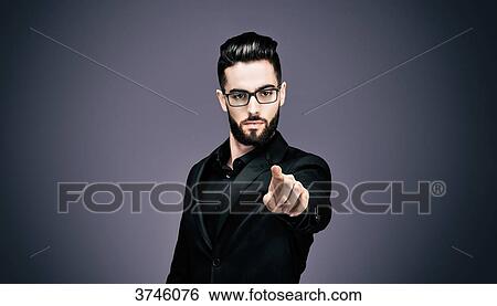Portrait of a young businessman pointing to the lens View Large Photo Image Stock Photograph - Portrait of a young businessman pointing to the lens. Fotosearch