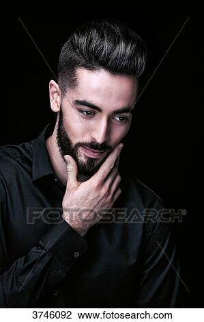 Portrait of a young man, hand on chin, looks down View Large Photo Image Stock Image - Portrait of a young man, hand on chin, looks down. Fotosearch