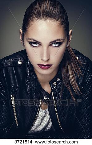 Portrait of a young woman hair pulled, face, arms crossed, looking toward the lens View Large Photo Image Picture - Portrait of a young woman hair pulled, face, arms crossed, looking toward the lens. Fotosearch