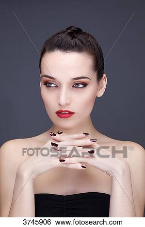 Portrait of a young woman hands under chin, looking to the side View Large Photo Image Stock Photograph - Portrait of a young woman hands under chin, looking to the side. Fotosearch