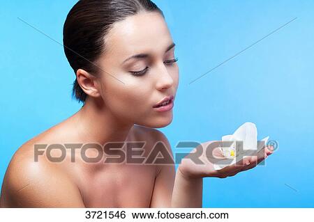 Portrait of a young woman holding a flower in hand View Large Photo Image Stock Photograph - Portrait of a young woman holding a flower in hand. Fotosearch