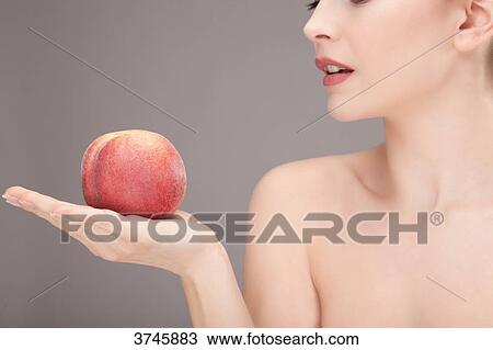 Portrait of a young woman holding an apple in his hand View Large Photo Image Stock Image - Portrait of a young woman holding an apple in his hand. Fotosearch