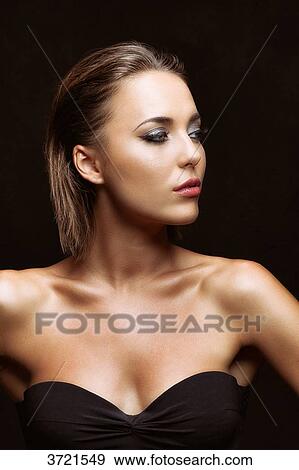 Stock Photo - Portrait of a young woman in profile, looking to the side. Fotosearch