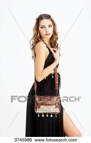 Portrait of a young woman in profile, wearing a handbag and a black dress Sanhadja View Large Photo Image Stock Photograph - Portrait of a young woman in profile, wearing a handbag and a black dress Sanhadja. Fotosearch