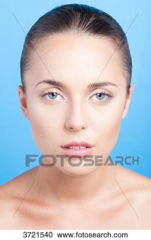 Stock Image - Portrait of a young woman looking at camera. Fotosearch