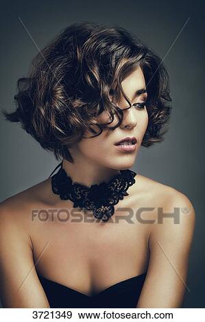 Stock Photo - Portrait of a young woman, looking to the side. Fotosearch