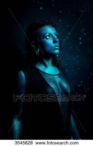 Portrait of a young woman painted in blue looking at the light View Large Photo Image Stock Photo - Portrait of a young woman painted in blue looking at the light. Fotosearch