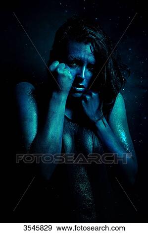 Portrait of a young woman painted in light blue and fearful attitude View Large Photo Image Stock Photo - Portrait of a young woman painted in light blue and fearful attitude. Fotosearch