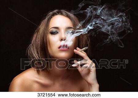 Portrait of a young woman with a cigarette in hand View Large Photo Image Picture - Portrait of a young woman with a cigarette in hand. Fotosearch