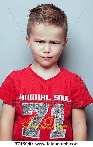 Stock Image - Portrait of an angry boy, looking toward the lens. Fotosearch