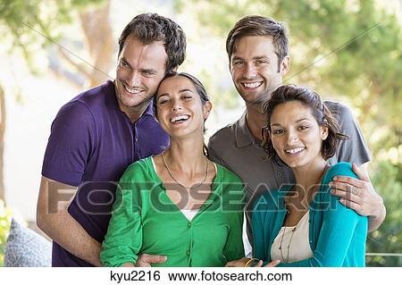 Stock Photograph - Portrait of four friends smiling. Fotosearch