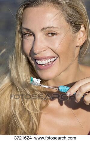 Portrait of smiling blond woman with toothbrush View Large Photo Image Picture - Portrait of smiling blond woman with toothbrush. Fotosearch
