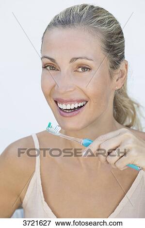 Portrait of smiling blond woman with toothbrush View Large Photo Image Stock Photo - Portrait of smiling blond woman with toothbrush. Fotosearch