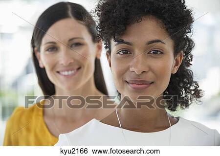 Stock Photograph - Portrait of two female friends smiling together. Fotosearch