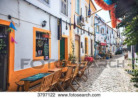 restaurant terraces in a paved street of the village Ferragudo, Algarve region, Portugal View Large Photo Image Stock Image - restaurant terraces in a paved street of the village Ferragudo, Algarve region, Portugal. Fotosearch