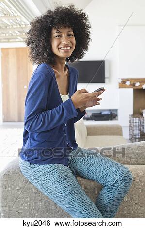 Smiling woman using a mobile phone View Large Photo Image Stock Photograph - Smiling woman using a mobile phone. Fotosearch