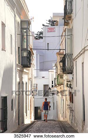 Spain, Andalusia, Tarifa, tourist in a narrow street View Large Photo Image Stock Photo - Spain, Andalusia, Tarifa, tourist in a narrow street. Fotosearch