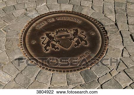 Switzerland, Canton of Vaud, region of Leman, Lausanne, close-up on the pavement and on a sewer drain with he city coats of arms on it in the old town View Large Photo Image Stock Image - Switzerland, Canton of Vaud, region of Leman, Lausanne, close-up on the pavement and on a sewer drain with he city coats of arms on it in the old town. Fotosearch