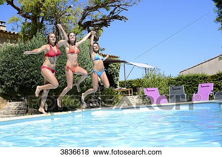 Three beautiful young woman with swimsuit jumping in the pool of a resort during fun holiday sunny summer day. View Large Photo Image Stock Photo - Three beautiful young woman with swimsuit jumping in the pool of a resort during fun holiday sunny summer day.. Fotosearch