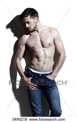 Topless man against a white wall; wearing jeans, serious, hand in the pocket, hard shadow on the wall, looking down, face in profile View Large Photo Image Stock Photo - Topless man against a white wall; wearing jeans, serious, hand in the pocket, hard shadow on the wall, looking down, face in profile. Fotosearch