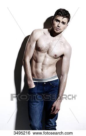 Topless man against a white wall; wearing jeans, serious, hand in the pocket, hard shadow on the wall, beaten look View Large Photo Image Stock Photograph - Topless man against a white wall; wearing jeans, serious, hand in the pocket, hard shadow on the wall, beaten look. Fotosearch