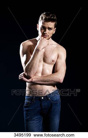 Topless man, black background; one hand on his chin, wearing jeans, serious, forehead creased. View Large Photo Image Stock Photo - Topless man, black background; one hand on his chin, wearing jeans, serious, forehead creased.. Fotosearch