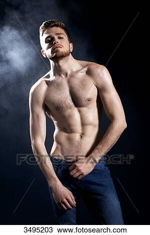Topless man, dark blue background; one hand the waistline of his trousers, wearing jeans, serious, disdainful, head up, smoke behind. View Large Photo Image Stock Image - Topless man, dark blue background; one hand the waistline of his trousers, wearing jeans, serious, disdainful, head up, smoke behind.. Fotosearch