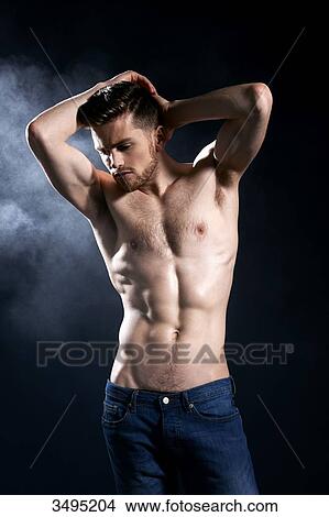 Topless man, dark blue background; wearing jeans, serious, forehead creased, arms up, hands behind his head, looking down, hands in jeans back pockets, smoke behind. View Large Photo Image Picture - Topless man, dark blue background; wearing jeans, serious, forehead creased, arms up, hands behind his head, looking down, hands in jeans back pockets, smoke behind.. Fotosearch