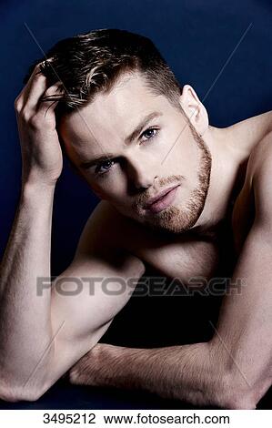 Topless man, dark blue background; lying on the floor, serious, one hand in his hair, View Large Photo Image Stock Image - Topless man, dark blue background; lying on the floor, serious, one hand in his hair,. Fotosearch