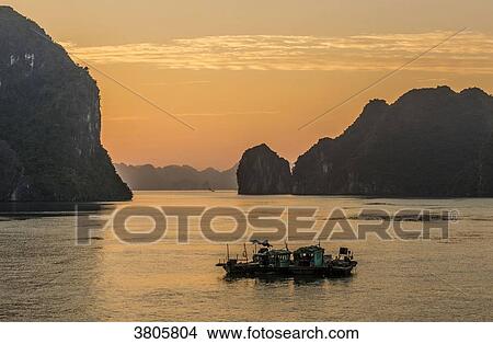 Vietnam, Ha Long Bay, fishers small boats at sunset, (UNESCO World Heritage) View Large Photo Image Picture - Vietnam, Ha Long Bay, fishers small boats at sunset, (UNESCO World Heritage). Fotosearch