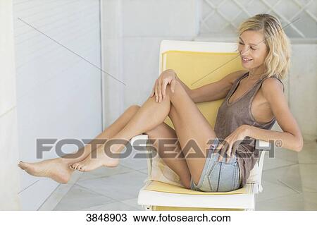 view of blonde woman siiting in chair with beauty legs. View Large Photo Image Stock Image - view of blonde woman siiting in chair with beauty legs.. Fotosearch