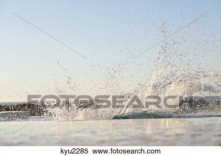 Stock Photography - Water being splashed into a swimming pool. Fotosearch