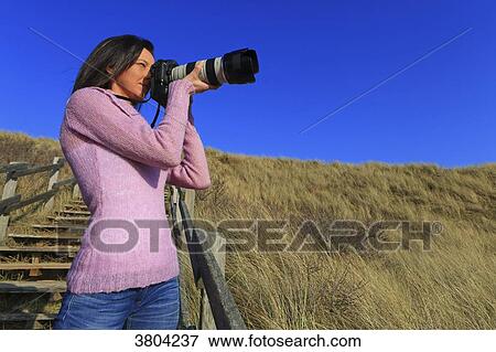 Woman at beach with professional camera View Large Photo Image Stock Photo - Woman at beach with professional camera. Fotosearch
