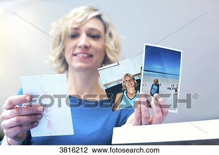 Stock Image - Woman at home looking at pictures. Fotosearch