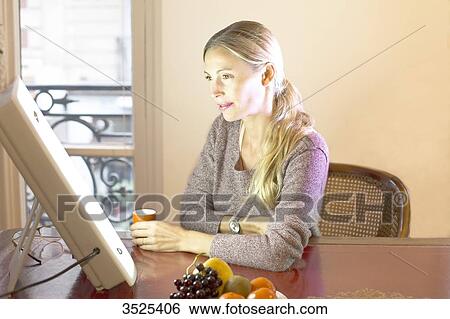 Stock Photograph - Woman doing a session of light therapy. Fotosearch