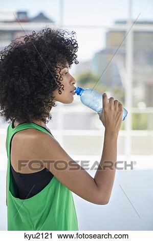 Stock Image - Woman drinking water from a bottle. Fotosearch
