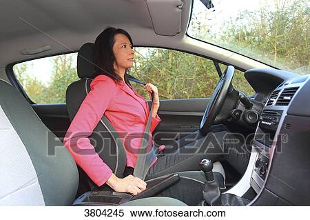 Woman fasten seat belt in her car View Large Photo Image Stock Photography - Woman fasten seat belt in her car. Fotosearch