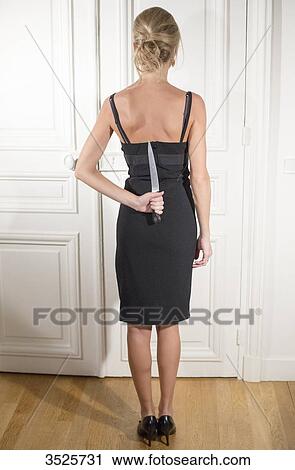 Woman hiding kitchen knife in her back View Large Photo Image Stock Image - Woman hiding kitchen knife in her back. Fotosearch