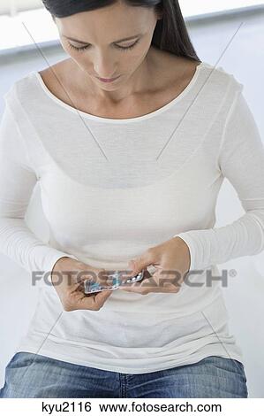 Woman holding a blister pack of contraceptive pills View Large Photo Image Stock Photograph - Woman holding a blister pack of contraceptive pills. Fotosearch