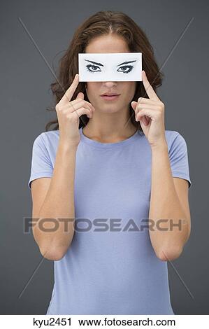 Woman holding a paper with false eyes in front of her face View Large Photo Image Stock Image - Woman holding a paper with false eyes in front of her face. Fotosearch