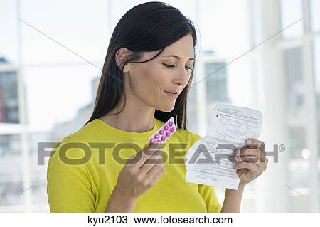 Woman holding medicine and reading instructions View Large Photo Image Stock Image - Woman holding medicine and reading instructions. Fotosearch