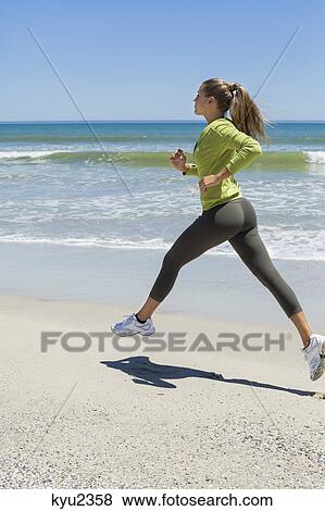 Stock Photo - Woman jogging on the beach. Fotosearch