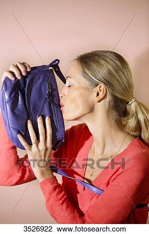 Woman kissing her bag View Large Photo Image Stock Image - Woman kissing her bag. Fotosearch