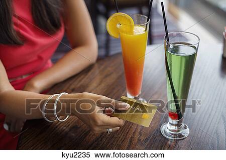 Stock Photography - Woman paying with a credit card on a table in a restaurant. Fotosearch