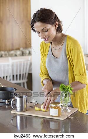 Woman preparing herbal tea in the kitchen View Large Photo Image Stock Image - Woman preparing herbal tea in the kitchen. Fotosearch